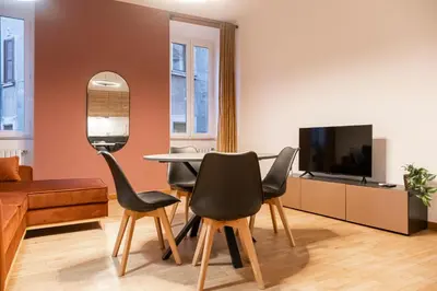 a living room with a table and chairs and a tv at Pallaro 6 Apartment in Rome