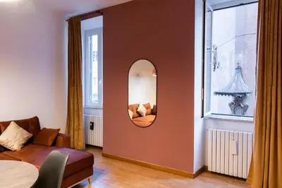 a living room with a mirror and a couch at Pallaro 6 Apartment in Rome