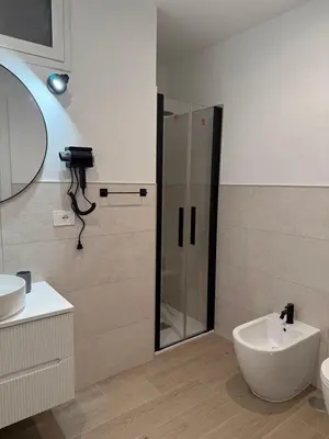 a bathroom with a shower and a toilet and a sink at Vita Lux Vatican Suites in Rome