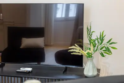 a living room with a mirror and a vase with a plant at iFlat Monti Brand New Peaceful Apartment in Rome