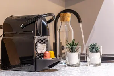 a bottle of wine sitting next to a toaster at iFlat Monti Brand New Peaceful Apartment in Rome