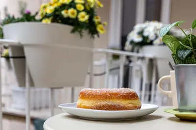 a pastry on a plate on a table with flowers at iFlat Monti Brand New Peaceful Apartment in Rome