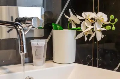 a bathroom sink with a candle and flowers on it at iFlat Monti Brand New Peaceful Apartment in Rome