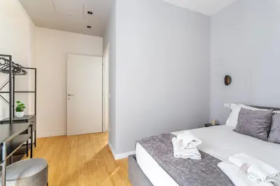 a white bedroom with a bed and a desk at iFlat Monti Brand New Peaceful Apartment in Rome