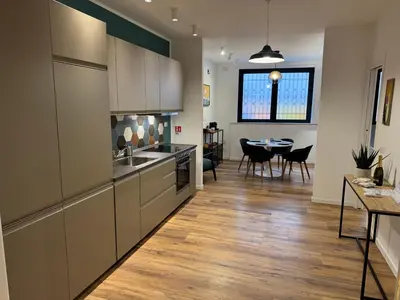 a kitchen with white cabinets and a dining room at Luce suite trastevere in Rome