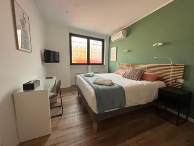 a bedroom with a bed and a desk and a television at Luce suite trastevere in Rome