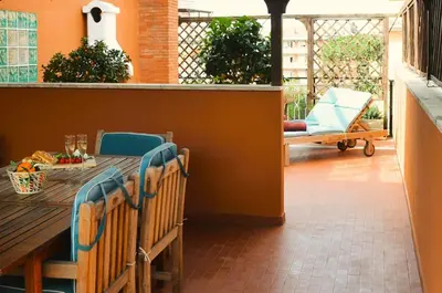 a deck with a wooden table and chairs on a patio at Attico Aurelia Antica in Rome