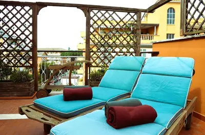 a blue couch sitting on top of a patio at Attico Aurelia Antica in Rome