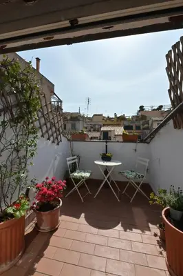 a patio with a table and chairs and plants at Domus Greci Piazza di Spagna in Rome