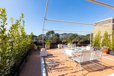 a patio with chairs and a table on a roof at San Pancrazio Penthouse by Rental in Rome in Rome