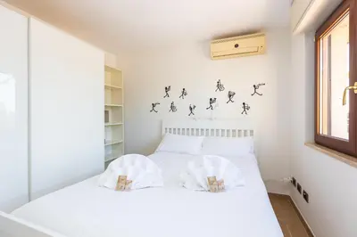 a bedroom with a white bed with two pillows at San Pancrazio Penthouse by Rental in Rome in Rome