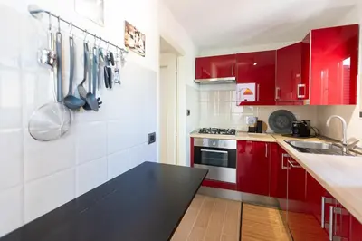 a red and white kitchen with red cabinets at San Pancrazio Penthouse by Rental in Rome in Rome