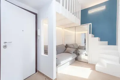 a living room with a couch and stairs at Rhome Vatican Chic in Rome