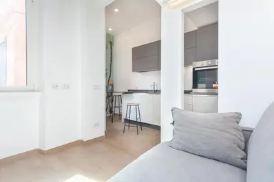 a living room with a couch and a kitchen at Rhome Vatican Chic in Rome