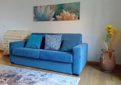 a blue couch in a living room with a painting at Casita in Rome