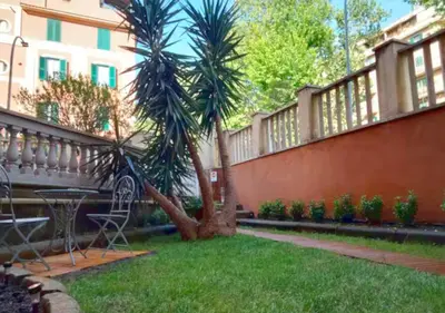 a patio with a table and a palm tree in a yard at Casita in Rome