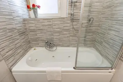 a bath tub in a bathroom with a shower at Roma Big terrace Home in Rome