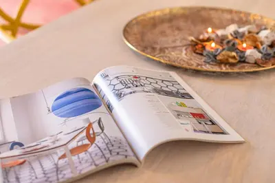 a magazine on a table next to a plate of food at YCH-Unique apartment near Vatican in Rome