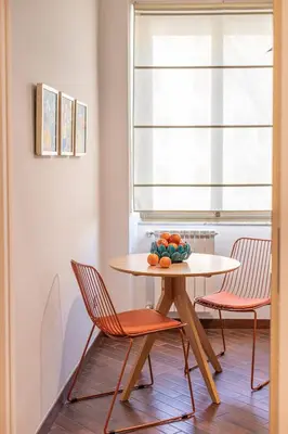 a table with two chairs and a bowl of fruit on it at YCH-Unique apartment near Vatican in Rome