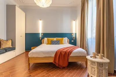 a bedroom with a large bed with a blue wall at YCH-Unique apartment near Vatican in Rome