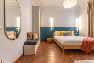 a bedroom with a bed and a mirror and a chair at YCH-Unique apartment near Vatican in Rome