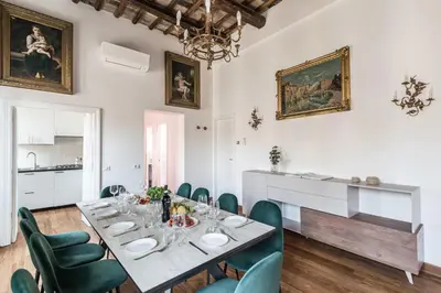 a dining room with a long table and green chairs at The Best Rent - Spacious multi-room apartment on Via Cavour in Rome