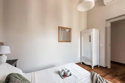 a white bedroom with a bed and a mirror at The Best Rent - Spacious multi-room apartment on Via Cavour in Rome