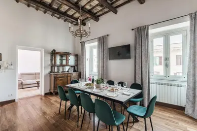 a dining room with a table and green chairs at The Best Rent - Spacious multi-room apartment on Via Cavour in Rome