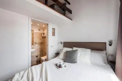 a bedroom with a white bed and a bathroom at The Best Rent - Spacious multi-room apartment on Via Cavour in Rome