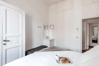 a white bedroom with a bed with a tray of bread at The Best Rent - Spacious multi-room apartment on Via Cavour in Rome