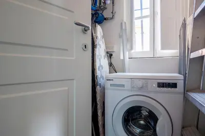 a laundry room with a washing machine and a window at The Best Rent - Spacious multi-room apartment on Via Cavour in Rome