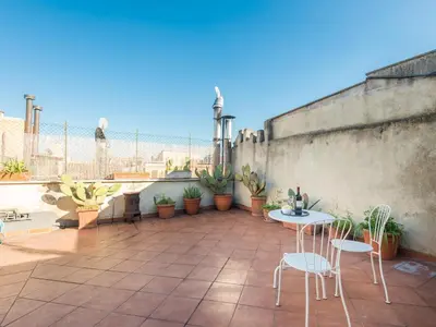 a patio with chairs and a table and potted plants at Central Rome Terrace Apartment in Rome