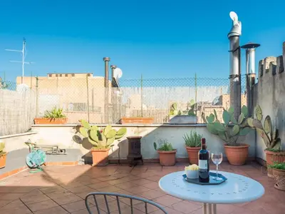 a patio with a table with a bottle of wine at Central Rome Terrace Apartment in Rome
