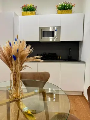 a glass table with a vase with flowers in a kitchen at Sweet Life Monteverde in Rome