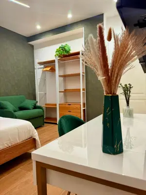 a living room with a white table and a green couch at Sweet Life Monteverde in Rome