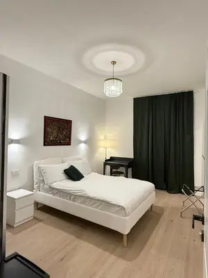 a bedroom with a white bed and a green curtain at Vita Lux Vatican Suites in Rome