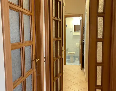 a hallway with doors and a bathroom with a toilet at MARIA TERESA Apartment - Sophisticated Living and City Links - Quartiere TRIESTE in Rome