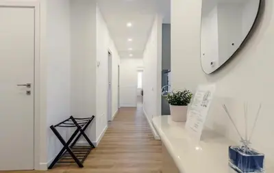 a white bedroom with a bed and a window at San Lorenzo Home in Rome