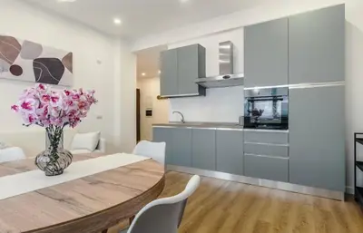 a kitchen and dining room with a wooden table and chairs at San Lorenzo Home in Rome