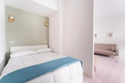 a bedroom with a white bed and a couch at Retrò Loft Ponte Milvio, Nearby Foro Italico in Rome