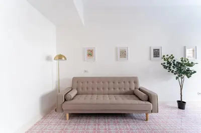 a couch in a living room with a plant at Retrò Loft Ponte Milvio, Nearby Foro Italico in Rome