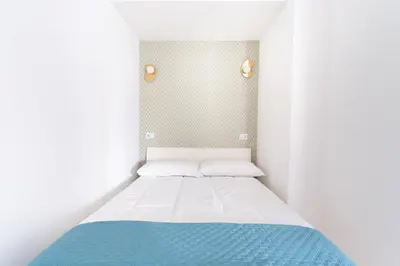 a small bedroom with a bed with a blue blanket at Retrò Loft Ponte Milvio, Nearby Foro Italico in Rome