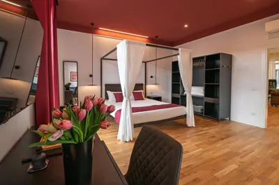 a bedroom with a bed and a table with a vase of flowers at EFFE 9 FLAMINIO Guest House in Rome-Vatican City in Rome