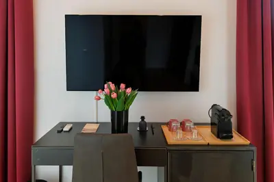 a desk with a vase of pink flowers on it at EFFE 9 FLAMINIO Guest House in Rome-Vatican City in Rome