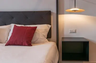 a bedroom with a bed with a red pillow and a nightstand at EFFE 9 FLAMINIO Guest House in Rome-Vatican City in Rome