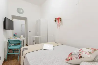 a bedroom with a bed and a desk with a laptop at Roma MetroB Apartment in Rome