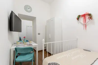 a bedroom with a bed and a desk and a tv at Roma MetroB Apartment in Rome