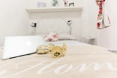 a bedroom with a white bed with shoes on it at Roma MetroB Apartment in Rome