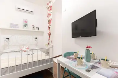 a room with a crib and a table and a tv at Roma MetroB Apartment in Rome