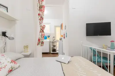 a white bedroom with a laptop on a bed at Roma MetroB Apartment in Rome